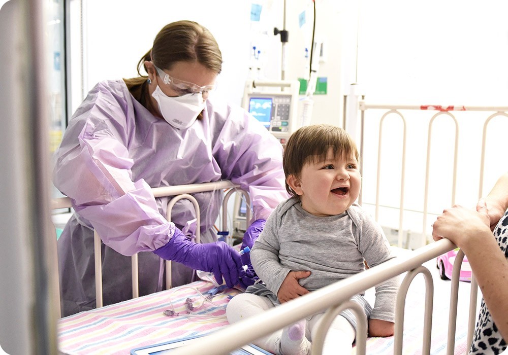 Baby smiling in hospital cot - Sydney Children's Hospital Foundation Baby smiling in hospital cot - Sydney Children's Hospital Foundation
